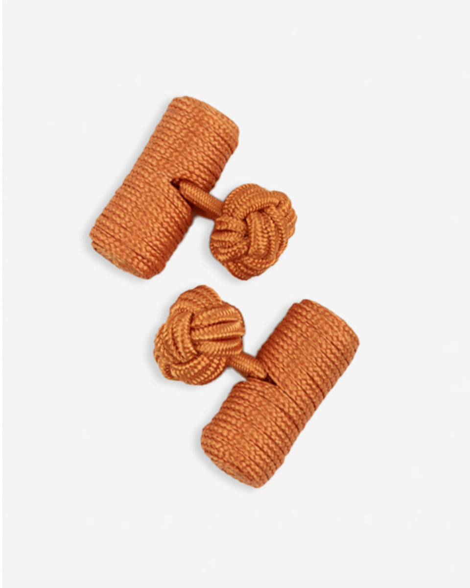Cufflinks in the shape of a woven knot, made of metal and gold plated